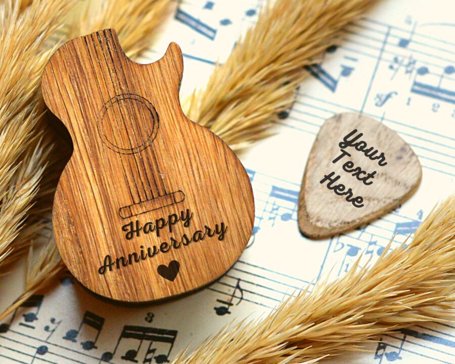 a wooden guitar shaped pick box with engraved picks
