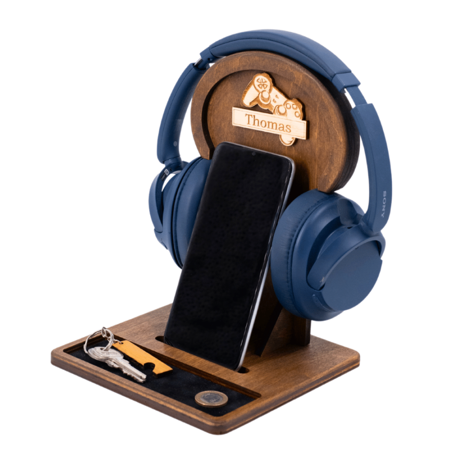 A brown wooden headphone stand with headphones and a phone